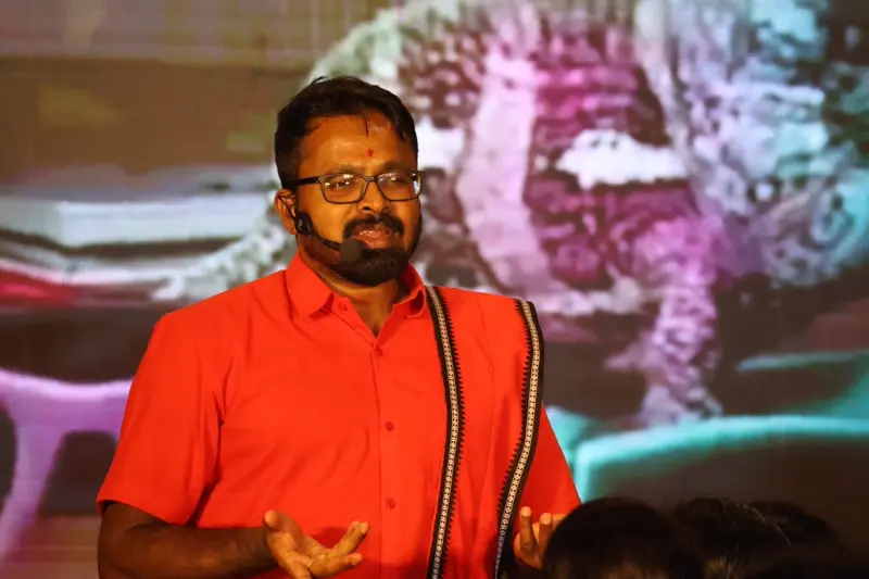 Guruji speaking during workshop in a red outfit